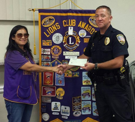 Lemoore Police Department seeks funds for its annual shoe drive to help local kids Officer Kevin Cosper accepts a donation from Lemoore Lions Club President Ever Casas.
